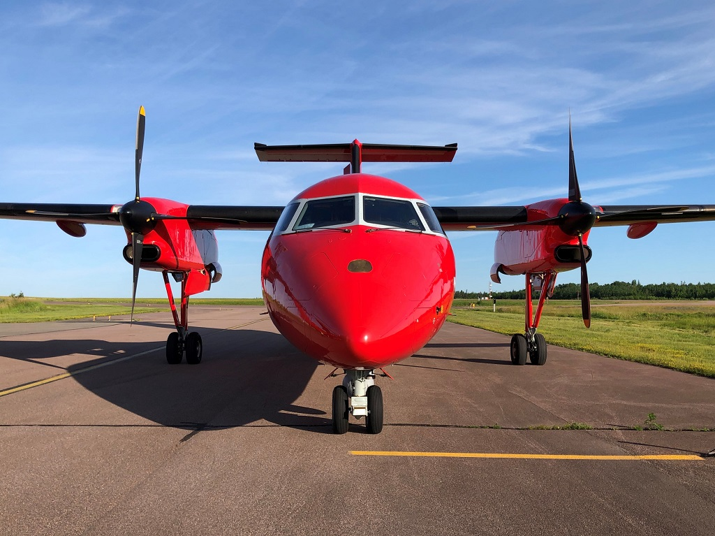 Un avion rouge emblématique du Programme national de surveillance aérienne du Canada s’apprête à décoller.