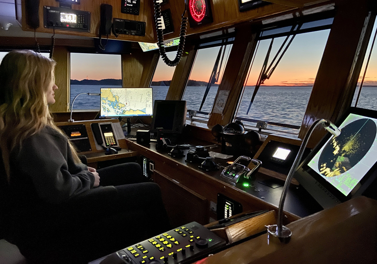 Lauryn Delaney, a graduate of Transport Canada's Marine Training Program, sits in the vessel's command centre. 
