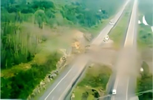 Site of explosives truck accident in Walden, Ontario, resulting in a detonation and the destruction of a large section of the highway and the nearby rock wall. There is no longer a visible truck after the detonation.